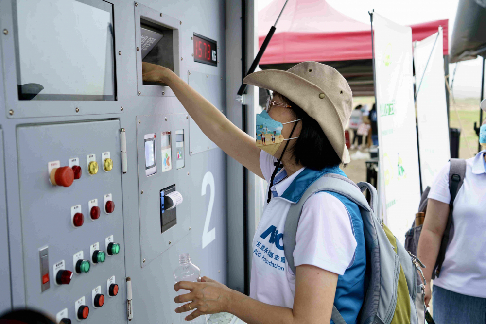 志工們將拾起的寶特瓶投入「好歸塑專車」，讓廢棄塑料空瓶可以直接粉碎、縮小體積，未來將可再製成購物袋、寶特衣、悠遊卡等生活用品